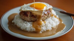 Loco moco with rice hamburger patty gravy and a fried egg on top